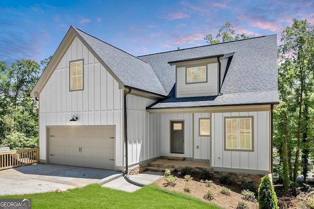 modern farmhouse style home featuring concrete driveway, board and batten siding, and roof with shingles