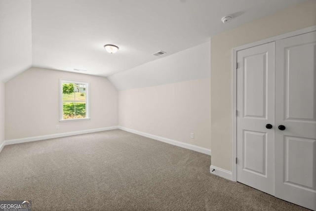 additional living space featuring carpet floors, baseboards, vaulted ceiling, and visible vents