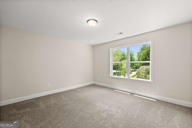 empty room with baseboards, carpet floors, and visible vents