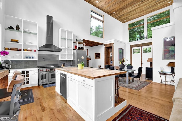 kitchen featuring open shelves, appliances with stainless steel finishes, high vaulted ceiling, wall chimney exhaust hood, and wood ceiling