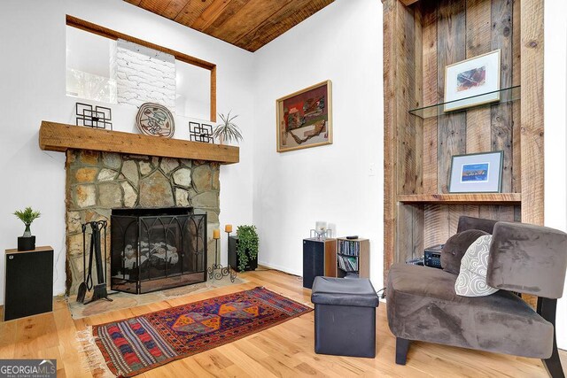 living area featuring wood ceiling, wood finished floors, and a fireplace