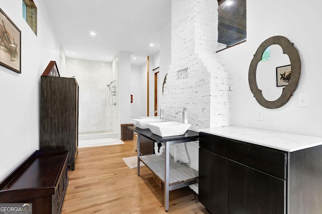 bathroom with recessed lighting, walk in shower, wood finished floors, and vanity