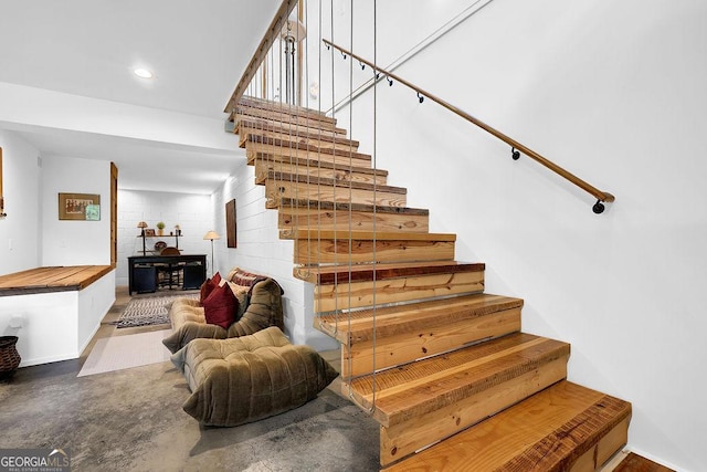 stairway featuring recessed lighting and finished concrete floors