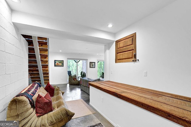 hallway with recessed lighting, concrete flooring, and concrete block wall