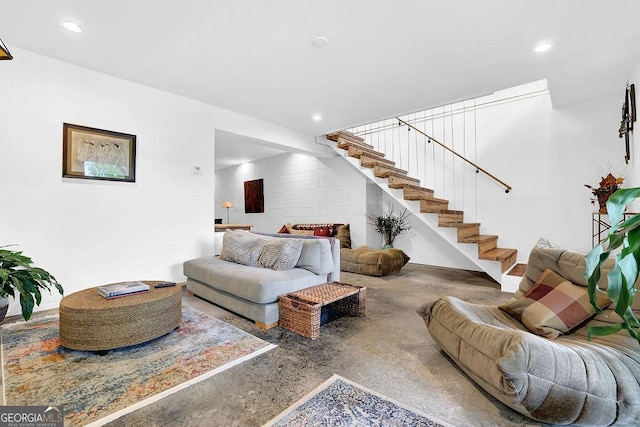 living area with recessed lighting, concrete flooring, and stairs