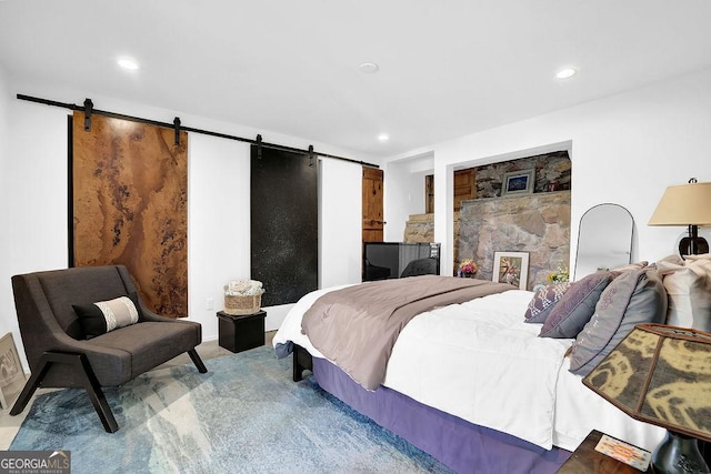 carpeted bedroom featuring recessed lighting and a barn door