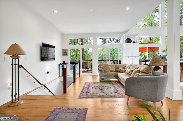 living room with recessed lighting, baseboards, and light wood-style floors