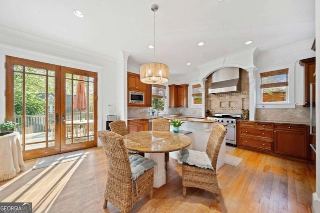 dining room with crown molding, french doors, a chandelier, and light wood-type flooring