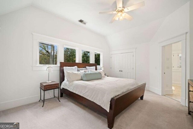 bedroom with light carpet, visible vents, and lofted ceiling