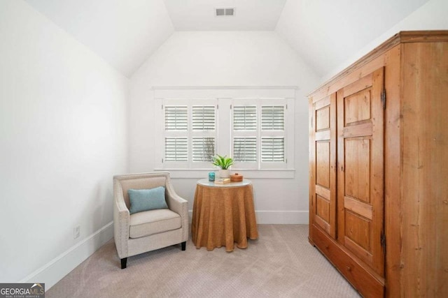 living area with light colored carpet, visible vents, baseboards, and vaulted ceiling