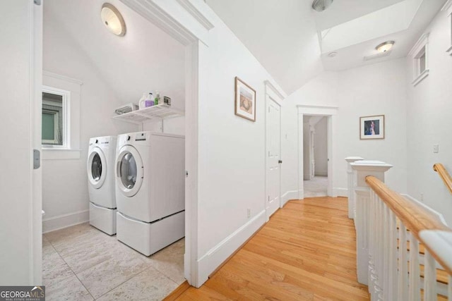 washroom with laundry area, light wood-style floors, baseboards, and separate washer and dryer