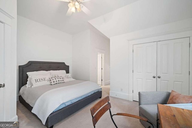 carpeted bedroom with a closet, baseboards, and a ceiling fan
