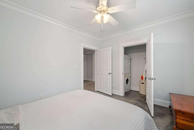 carpeted bedroom featuring baseboards, stacked washer and clothes dryer, ornamental molding, and a ceiling fan