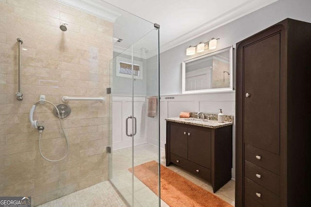 full bath featuring vanity, ornamental molding, tile patterned flooring, and a shower stall