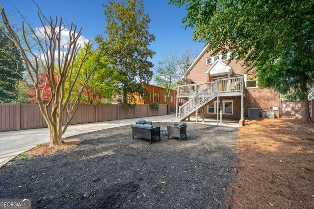 view of yard featuring cooling unit, a fenced backyard, stairway, and a wooden deck