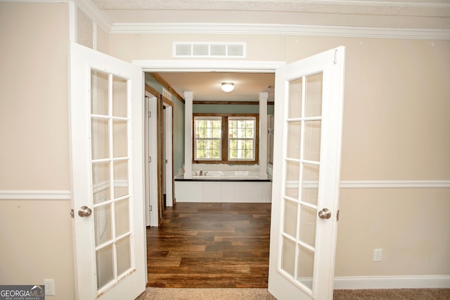 hallway featuring crown molding, visible vents, and dark wood finished floors