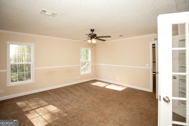 carpeted empty room featuring baseboards, visible vents, a textured ceiling, and crown molding