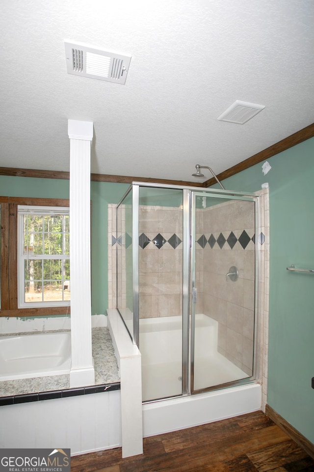full bathroom with crown molding, wood finished floors, visible vents, and a stall shower