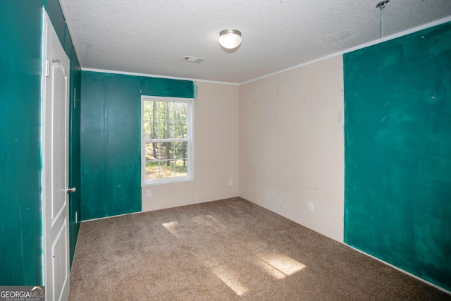 unfurnished room with a textured ceiling, carpet, and visible vents