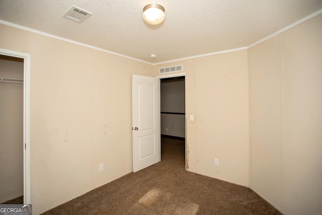 unfurnished bedroom with visible vents, carpet, a textured ceiling, and crown molding
