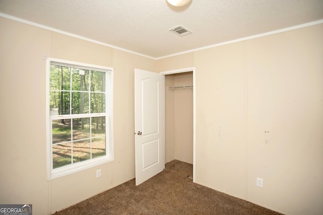 unfurnished bedroom featuring carpet floors, visible vents, and ornamental molding