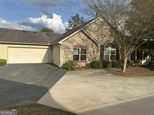 227 Fenwick Cir, Mcdonough, GA 30253 - view of front of house with asphalt driveway, stone siding, and an attached garage