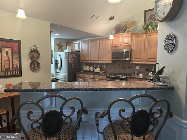 227 Fenwick Cir, Mcdonough, GA 30253 - kitchen featuring stainless steel appliances, dark countertops, a breakfast bar, tasteful backsplash, and pendant lighting