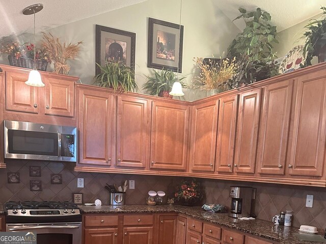 227 Fenwick Cir, Mcdonough, GA 30253 - kitchen with appliances with stainless steel finishes, vaulted ceiling, decorative backsplash, dark stone counters, and brown cabinets