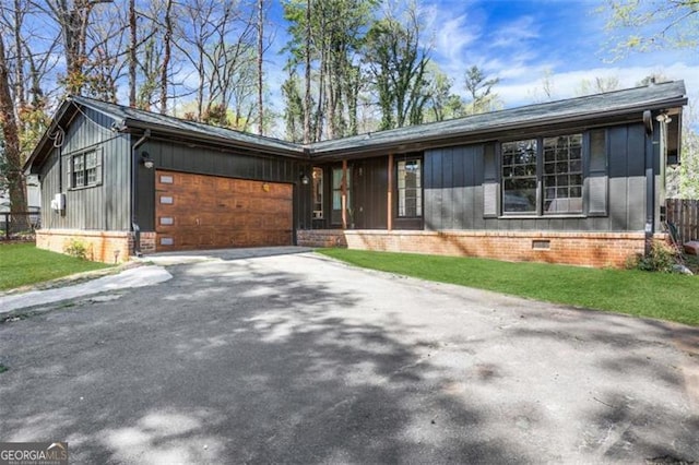 view of front of home featuring a front yard, crawl space, a garage, and driveway