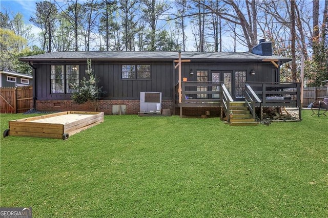 back of property featuring board and batten siding, fence, a yard, and a chimney