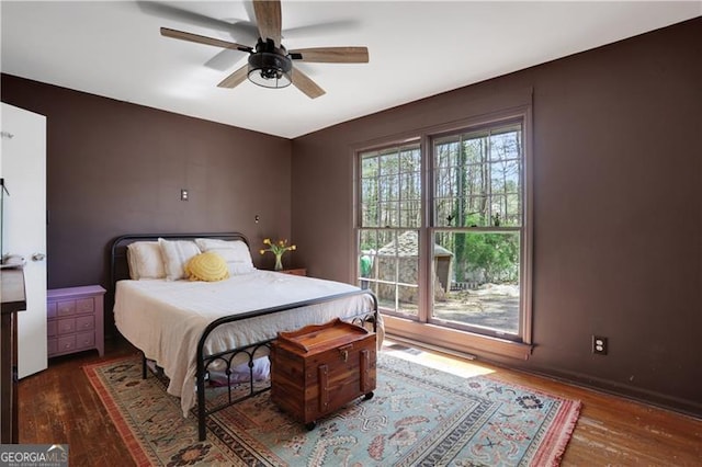 bedroom with baseboards, a ceiling fan, and wood finished floors