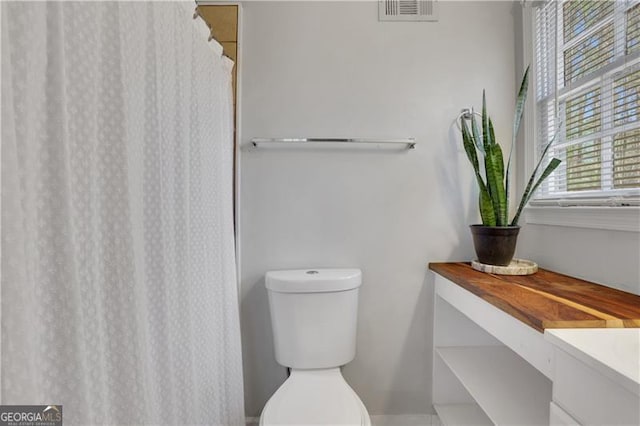 bathroom featuring visible vents, toilet, and a shower with shower curtain