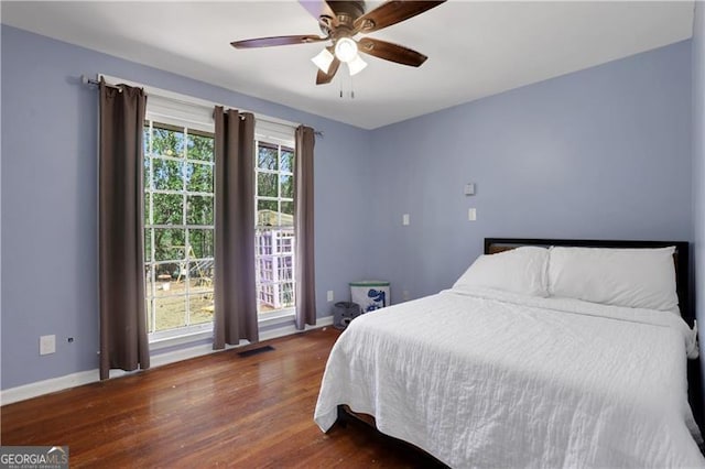 bedroom with wood finished floors, ceiling fan, baseboards, and visible vents