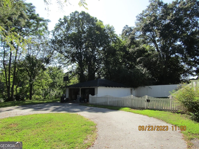 ranch-style house with driveway and a fenced front yard