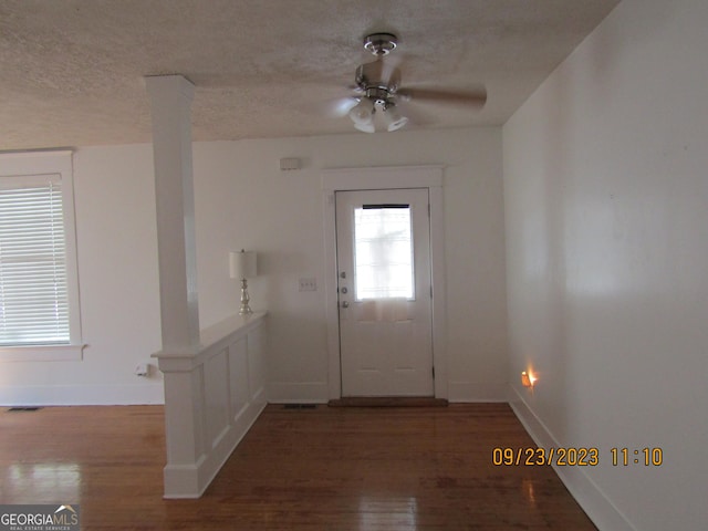 foyer entrance with a textured ceiling, wood finished floors, baseboards, and a ceiling fan