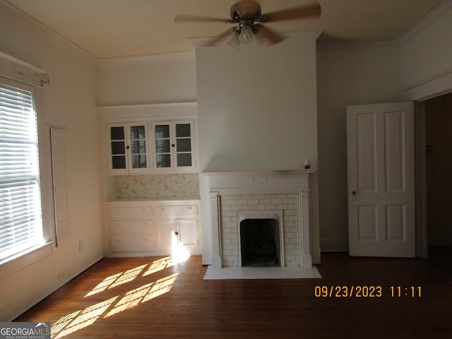 unfurnished living room with a ceiling fan, a healthy amount of sunlight, crown molding, and a brick fireplace