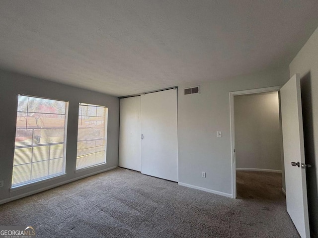 spare room featuring baseboards and dark colored carpet