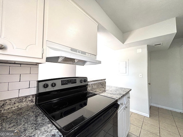kitchen featuring a textured ceiling, tasteful backsplash, dark stone countertops, white cabinetry, and a sink