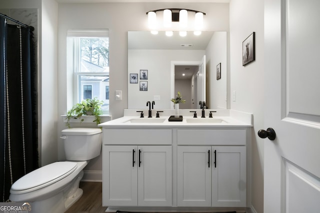 807 Stickley Oak Way, Woodstock, GA 30189 - bathroom with double vanity, a sink, toilet, and wood finished floors