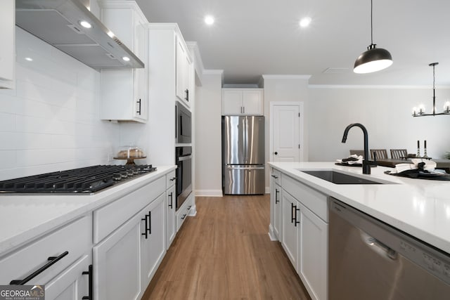 807 Stickley Oak Way, Woodstock, GA 30189 - kitchen with light countertops, crown molding, stainless steel appliances, a sink, and wall chimney range hood