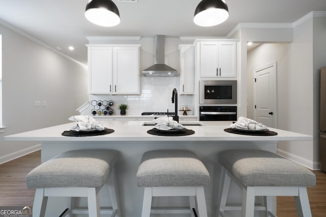 807 Stickley Oak Way, Woodstock, GA 30189 - kitchen featuring wall chimney exhaust hood, oven, built in microwave, crown molding, and a kitchen bar