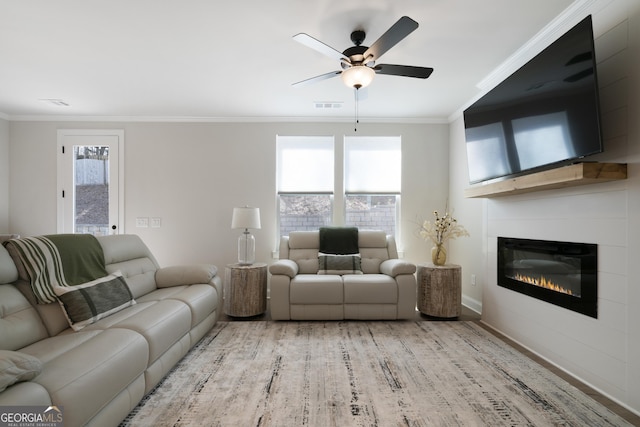807 Stickley Oak Way, Woodstock, GA 30189 - living area featuring visible vents, crown molding, light wood finished floors, ceiling fan, and a glass covered fireplace
