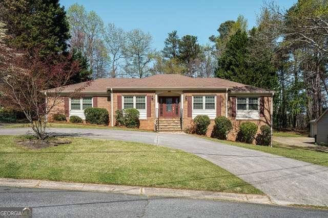 ranch-style house with a front lawn and curved driveway