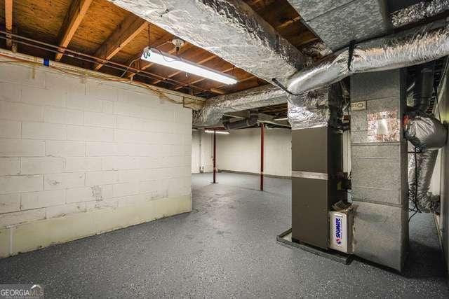 unfinished basement with heating unit and concrete block wall