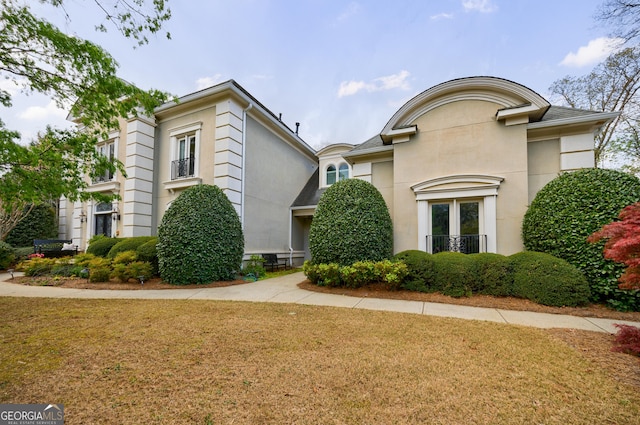 view of front of property featuring stucco siding and a front yard