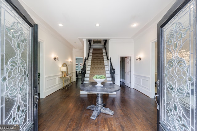 entryway featuring ornamental molding, stairs, a decorative wall, and a wainscoted wall