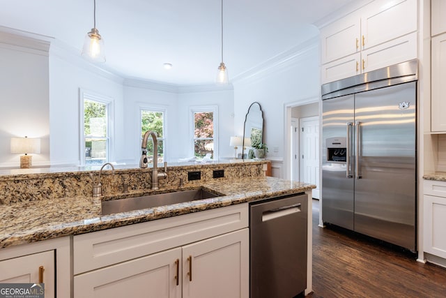 kitchen with a sink, ornamental molding, light stone countertops, and stainless steel appliances