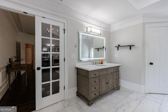 bathroom with vanity, ornamental molding, baseboards, and marble finish floor