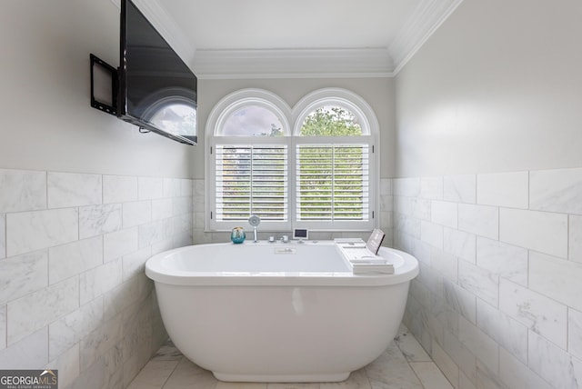 full bathroom with crown molding, a freestanding tub, tile walls, and a wainscoted wall