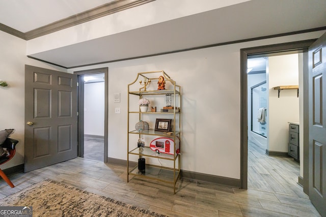 interior space featuring crown molding, baseboards, and wood finished floors